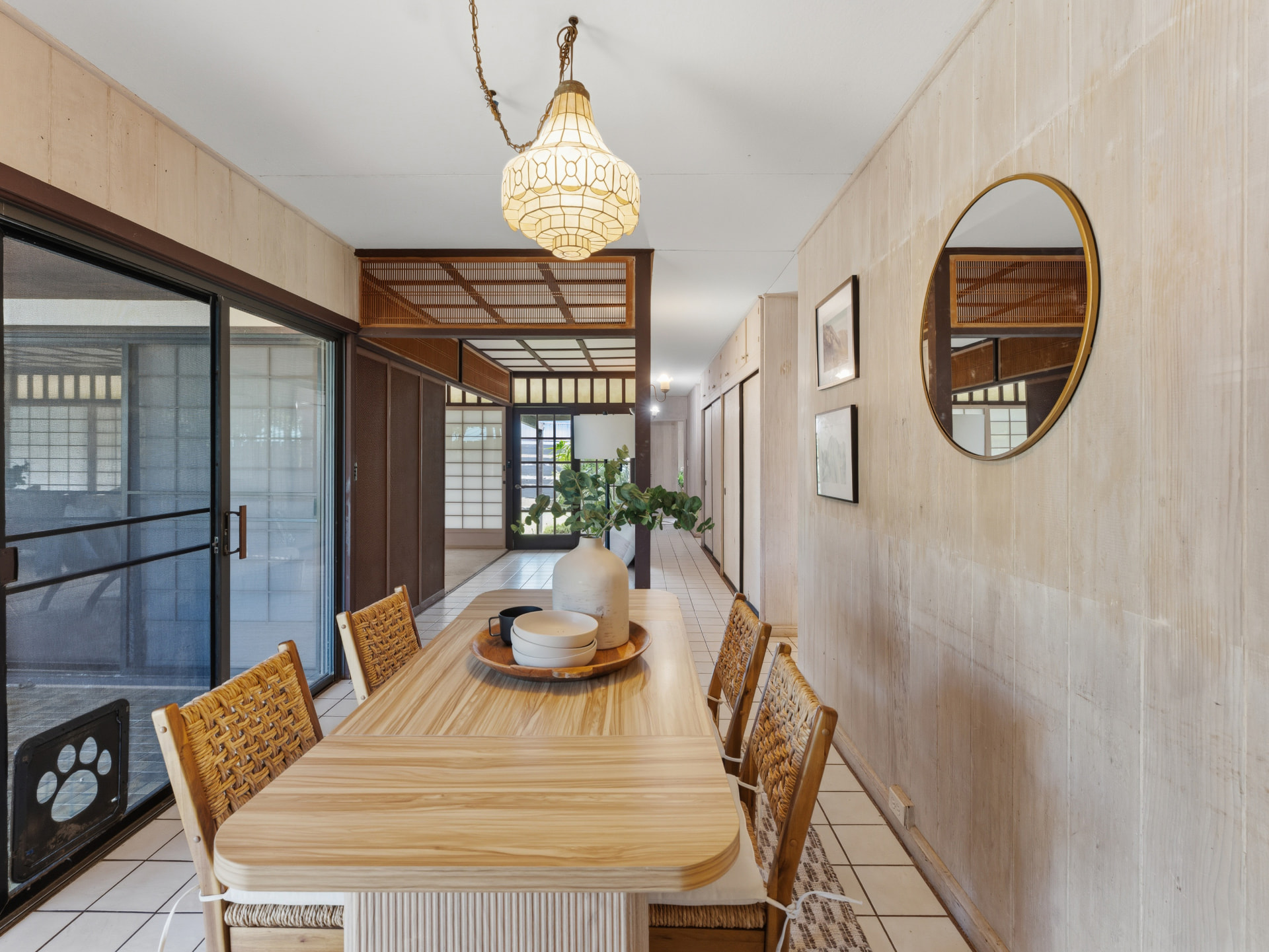 Long dining table in the tiled dining hall with sliding doors to the lanai