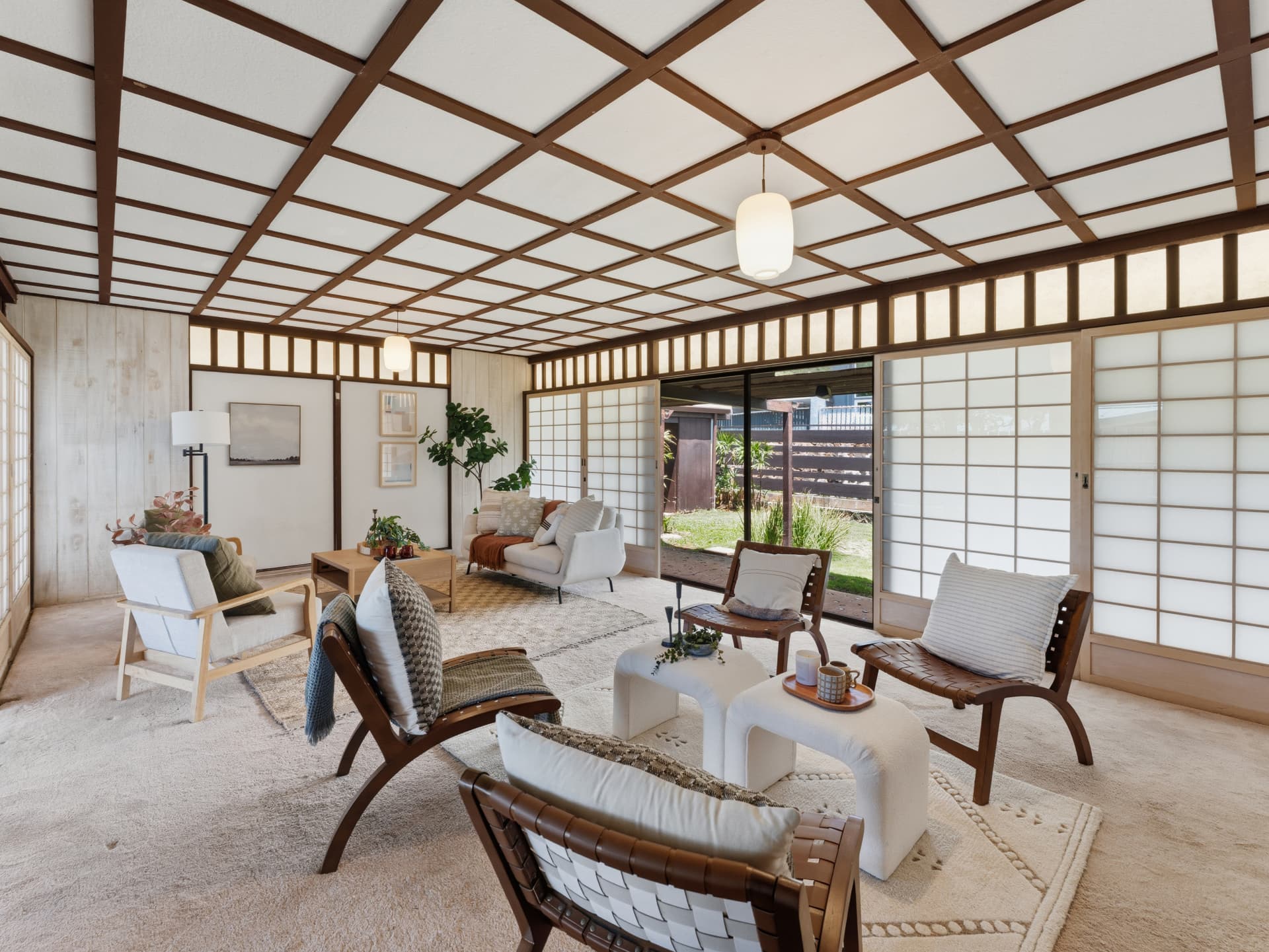 Open living area with shoji screens, mid-century seating, and garden views